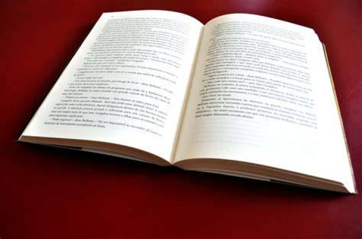 an open book with red writing on the page and some words written in