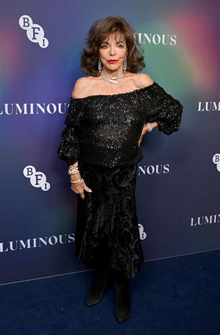 Joan Collins looks chic in a leopard print dress as she celebrates her