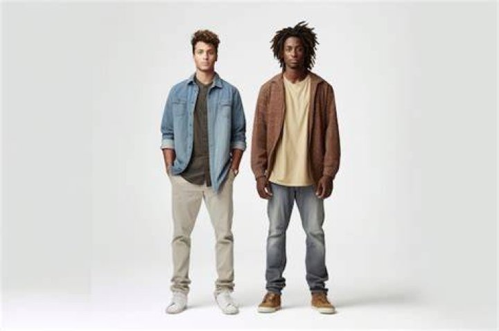 two men standing next to each other in front of a dj's turntable